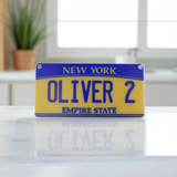 Personalized 4x2 inch mini New York state license plate for kids in durable plastic, close‑up view. State Plate for Kids, Car Toy, Wagon, Bike, Stroller – Thick Plastic Name Sign.