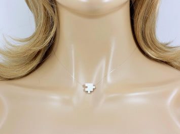 White puzzle piece pendant on a clear necklace. Lab Created Opal Puzzle Pendant Floating Illusion Necklace.