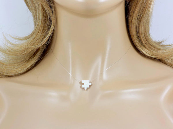 White puzzle piece pendant on a clear necklace. Lab Created Opal Puzzle Pendant Floating Illusion Necklace.