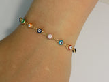 Multicolor evil eye bracelet held in a hand to show scale and detail of the tiny nazar charms.
