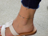 Multicolor evil eye bracelet worn on the ankle, showing the dainty gold‑plated chain and colorful charms